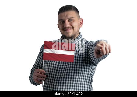 Homme blanc tenant un drapeau de la Lettonie et pointe en avant devant lui isolé sur un fond blanc. Banque D'Images