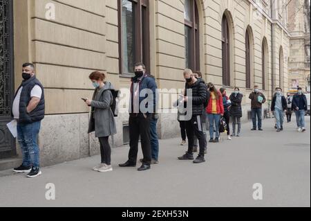 Budapest, Hongrie. 4 mars 2021. Les personnes portant un masque facial font la queue devant un bureau de poste à Budapest, en Hongrie, le 4 mars 2021. Le gouvernement hongrois a présenté jeudi un ensemble de règles plus strictes pour lutter contre la troisième vague de pandémie, les nouvelles infections quotidiennes ayant dépassé les 6,000 000, un niveau jamais vu depuis novembre dernier. Credit: Attila Volgyi/Xinhua/Alay Live News Banque D'Images