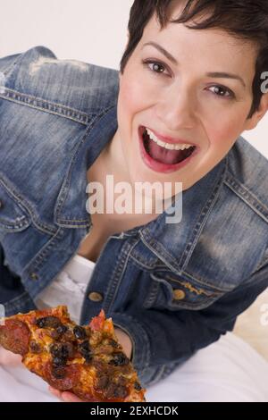 Heureux Attractive Woman Eating Hot Pizza Fond blanc Banque D'Images