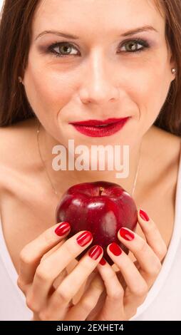 Mains de femmes manucures tenant Red Delicious Apple Banque D'Images