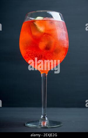 Cocktail rouge à base de rhum avec citron vert dans un verre à vin. Mise au point sélective. Faible profondeur de champ. Banque D'Images