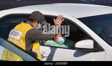 Un interprète mandarin fait une vague après avoir aidé le personnel militaire à administrer des tirs COVID-19 aux résidents locaux sur un site de vaccination de passage au volant sur le campus de Cal State LA à Los Angeles le jeudi 4 mars 2021. La Californie commencera à envoyer 40 % de toutes les doses de vaccin aux quartiers les plus vulnérables de l'État pour tenter d'inoculer les personnes les plus à risque du coronavirus et d'ouvrir plus rapidement l'économie de l'État, Gov. Gavin Newsom a déclaré jeudi lors de la dernière secousse aux règles de l'État. Photo de Jim Ruymen/UPI Banque D'Images