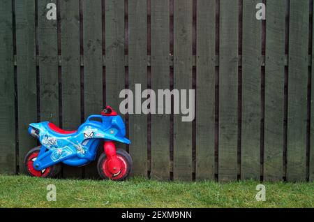 BRAY, IRLANDE - 26 mars 2020 : une moto en plastique colorée pour enfants se dresse sur l'herbe à côté de la clôture en bois. Vélo sur le thème « Ultimate Spider-Man ». Banque D'Images