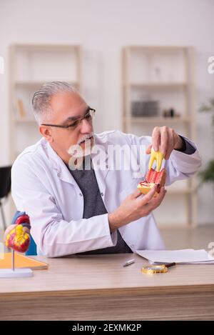 Ancien professeur de dentiste assis dans la salle de classe Banque D'Images