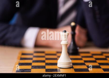 Un vieux employé d'homme d'affaires jouant aux échecs sur le lieu de travail Banque D'Images