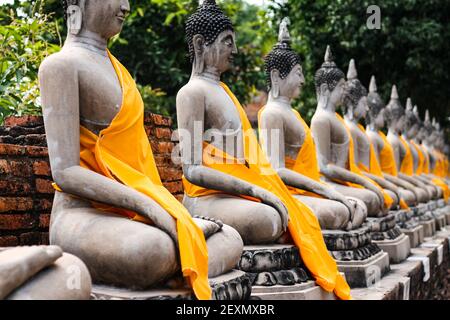 Une rangée de statues de Bouddha à Wat Yai Chaimongkhon à Ayutthaya, Thaïlande Banque D'Images