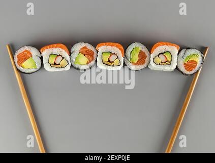 Des sushis japonais traditionnels placés entre des baguettes Banque D'Images