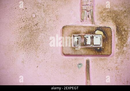 Une belle photo d'un ancien interrupteur de lumière sur un mur en brique sale de couleur rose clair Banque D'Images