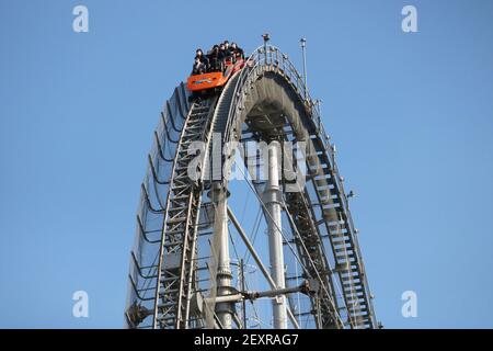 Des cavaliers sur les montagnes russes Thunder Dolphin des attractions de Tokyo Dome City portant des masques faciaux pendant l'épidémie de coronavirus. (2/2021) Banque D'Images