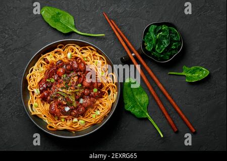 Bakmi ou Mie Ayam dans un bol noir sur une table en ardoise sombre. Cuisine indonésienne nouilles plat de viande. Plats et repas asiatiques traditionnels. Vue de dessus Banque D'Images