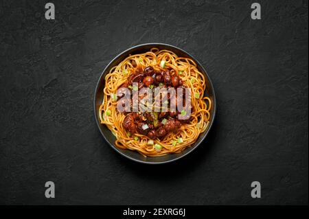 Bakmi ou Mie Ayam dans un bol noir sur une table en ardoise sombre. Cuisine indonésienne nouilles plat de viande. Plats et repas asiatiques traditionnels. Vue de dessus Banque D'Images