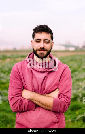 portrait vertical d'un jeune entrepreneur fermier devant son champ de ferme planté de plantes d'artichaut, concept d'esprit d'entreprise dans le pays Banque D'Images
