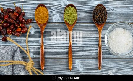Cuillères de différentes épices sur une table rustique en bois. Vue de dessus. Le concept de la cuisson de plats délicieux Banque D'Images