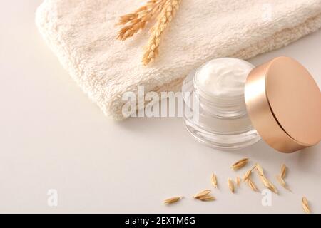 Crème hydratante pour le visage d'avoine dans un pot en verre avec des pointes sur la table blanche pour le traitement de l'acné. Vue en hauteur du dessus. Composition horizontale. Banque D'Images