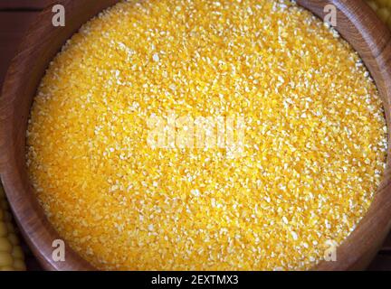 Polenta de gruau de maïs dans un bol en bois. Gros plan sur les épis de maïs Banque D'Images