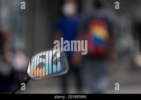 Caracas, Venezuela. 04e mars 2021. Une fresque représentant les yeux du regretté président vénézuélien Hugo Chavez se reflète dans le rétroviseur d'une moto. Un culte de la personnalité s'est développé autour du défunt président au Venezuela et il est commun de trouver des peintures murales de son visage dans la capitale. Le vendredi 5 mars marque le huitième anniversaire de sa mort. Credit: Pedro Ramses Mattey/dpa/Alay Live News Banque D'Images