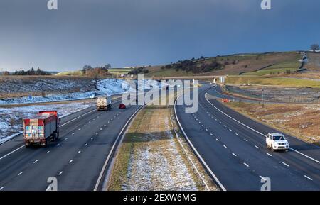 Trafic sur l'autoroute M6 à Shap dans Cumbria lors d'une soirée hivers. Banque D'Images