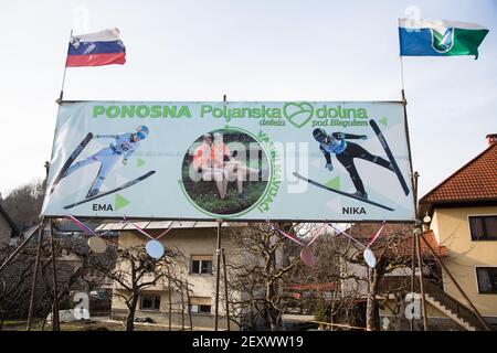 Poljane, Slovénie. 15 février 2021. Une grande bannière montrant le soutien et félicitant EMA Klinec avec Nika Kriznar, se tient à l'entrée de leur village d'origine de Poljane.Slovénie EMA Klinec, la championne du monde de saut à ski 2021 pour femmes et Nika Kriznar, Grand médaillé de bronze de championnat du monde de colline est revenu d'Oberstdorf à leur village d'origine avec des rues pleines de signes montrant le soutien. Crédit : SOPA Images Limited/Alamy Live News Banque D'Images