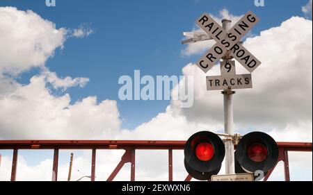 Train passant les feux d'avertissement du passage du chemin de fer clignotent Banque D'Images