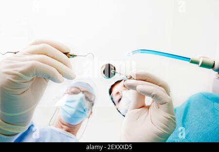 matériel chirurgical dentaire entre les mains du dentiste et de l'infirmière, fond blanc, espace pour le texte.espace pour le texte. Banque D'Images