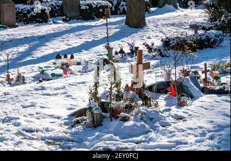 Cimetière de la paroisse de Sophien - croix, ornements et bougies commémoratives sur des tombes enneigées en hiver, Friedhof der Sophien Gemeinde, Mitte, Berlin, Allemagne Banque D'Images