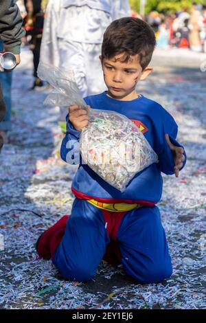 Portrait d'un jeune garçon en costume de super-homme tenant un sac de confetti dans la route pendant le Carnaval de Limassol, Chypre, 1er mars 2020 Banque D'Images