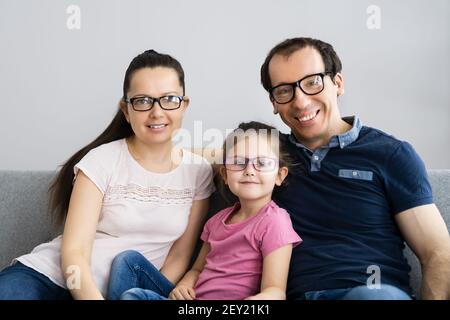 Famille avec fille enfant portant des lunettes dans le salon Banque D'Images