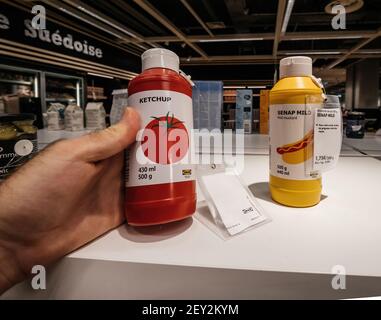 Paris, France - 28 juillet 2018: POV point de vue personnel homme shopping main dans Ikea magasin pour la nourriture délicieuse - ketchup de tomate et moutarde douce de SENAP avec le prix de 1 75 euros Banque D'Images