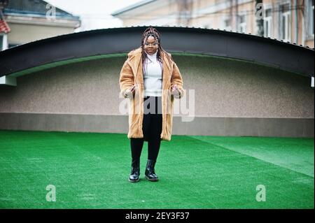 Femme afro-américaine glamour en manteau chaud de fourrure pose dans la rue. Banque D'Images