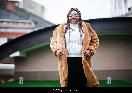 Femme afro-américaine glamour en manteau chaud de fourrure pose dans la rue. Banque D'Images