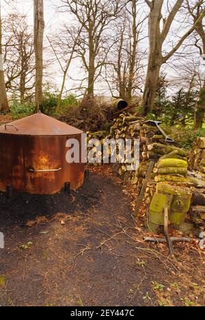 Un four ou four traditionnel de brûleur à charbon de bois et un tas De grumes dans une clairière de bois dans le nord du pays de Galles pour fabrication de charbon de bois traditionnel Banque D'Images