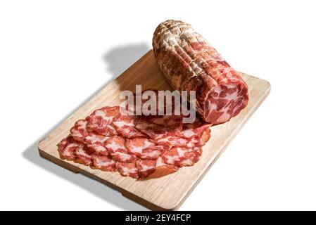 coppa piacentina de viande de porc, bacon roulé italien Pancetta. Salami coupé avec des tranches sur le panneau de coupe en bois isolé sur blanc Banque D'Images