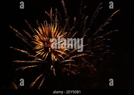 Orange doré feu d'artifice étonnant isolé sur un fond sombre gros plan Banque D'Images