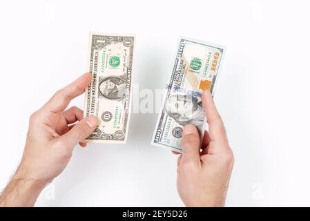 Une main d'homme détient un dollar américain et cent dollars. La plus petite et la plus grande facture. Concept de pauvreté et de richesse Banque D'Images