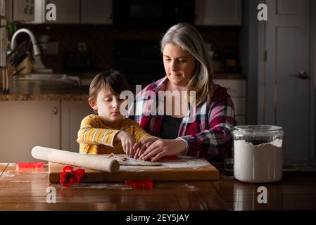 une mère et un fils qui cuisent des biscuits ensemble dans la cuisine tableau Banque D'Images