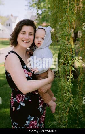Mère et bébé fils souriant et jouant dans la cour avant au printemps Banque D'Images