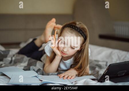 fille couchée sur le lit entourée de carnets Banque D'Images