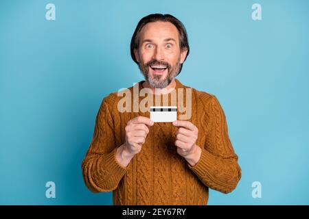 Photo portrait d'un homme d'affaires émerveillé démontrant une carte de débit en plastique avec mise en évidence bouche ouverte isolée sur fond bleu vif Banque D'Images