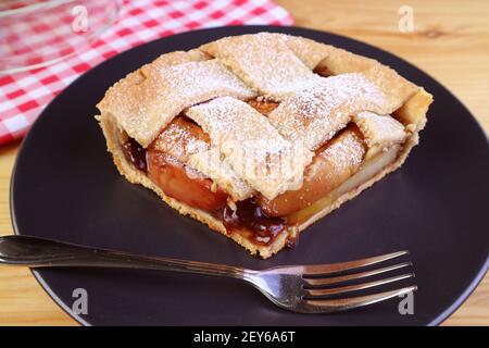 Tranche de tarte aux pommes maison appétissante sur une assiette noire Banque D'Images