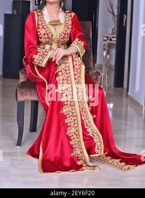 Une femme portant un caftan rouge marocain avec broderie dorée Banque D'Images