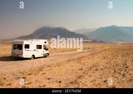 Voyage en voiture dans une maison de camping à travers la belle Damaraland, Namibie. Routes en gravier sans fin menant aux montagnes de Brandberg Banque D'Images