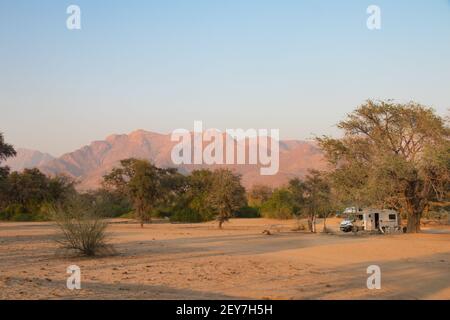 Voyage en voiture dans une maison de camping à travers la belle Damaraland, Namibie. wied étalée et site de camp de longue durée près de Brandberg. Les éléphants du désert passent à travers Banque D'Images