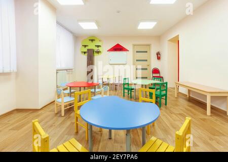 Tables colorées pour les cours pour enfants et salle de jeux beige clair dans la maternelle. Banque D'Images