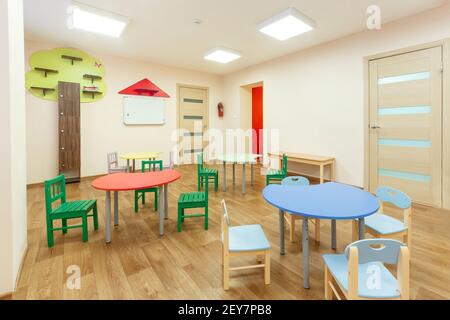 Tables colorées pour les cours pour enfants et salle de jeux beige clair dans la maternelle. Banque D'Images