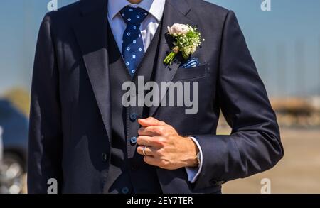 Le matin, le marié dans une veste, le marié redresse le boutonnière, le jour du mariage. Mariage. Détails Banque D'Images