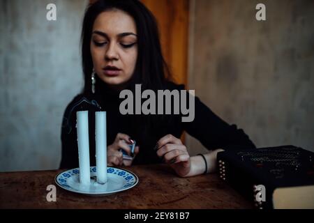 une fille de fortune teller allume des bougies pour prédire l'avenir. rituel mystique de la communication avec les esprits Banque D'Images