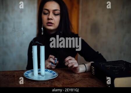 une fille de fortune teller allume des bougies pour prédire l'avenir. rituel mystique de la communication avec les esprits Banque D'Images