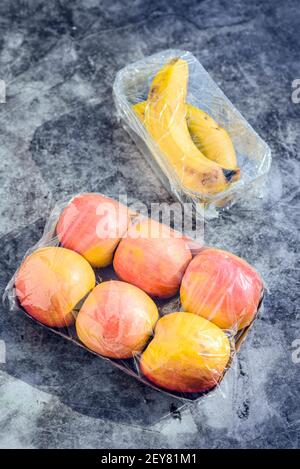 Fruits emballés dans du plastique inutile dans un supermarché Banque D'Images