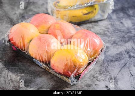 Fruits emballés dans du plastique inutile dans un supermarché Banque D'Images