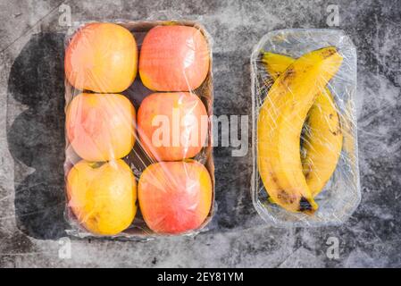 Fruits emballés dans du plastique inutile dans un supermarché Banque D'Images